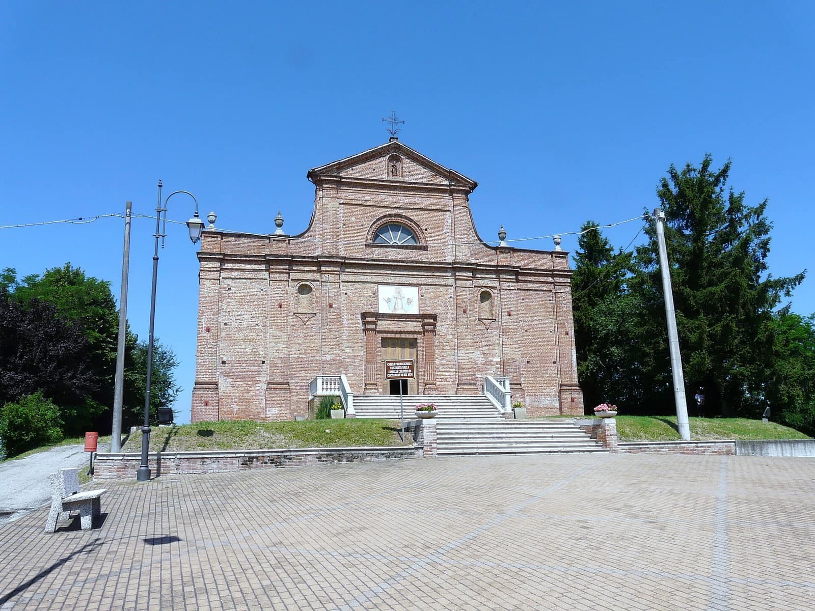 La chiesa di Santa Maria Assunta a Cuccaro Monferrato, con la facciata in mattoni e il sagrato