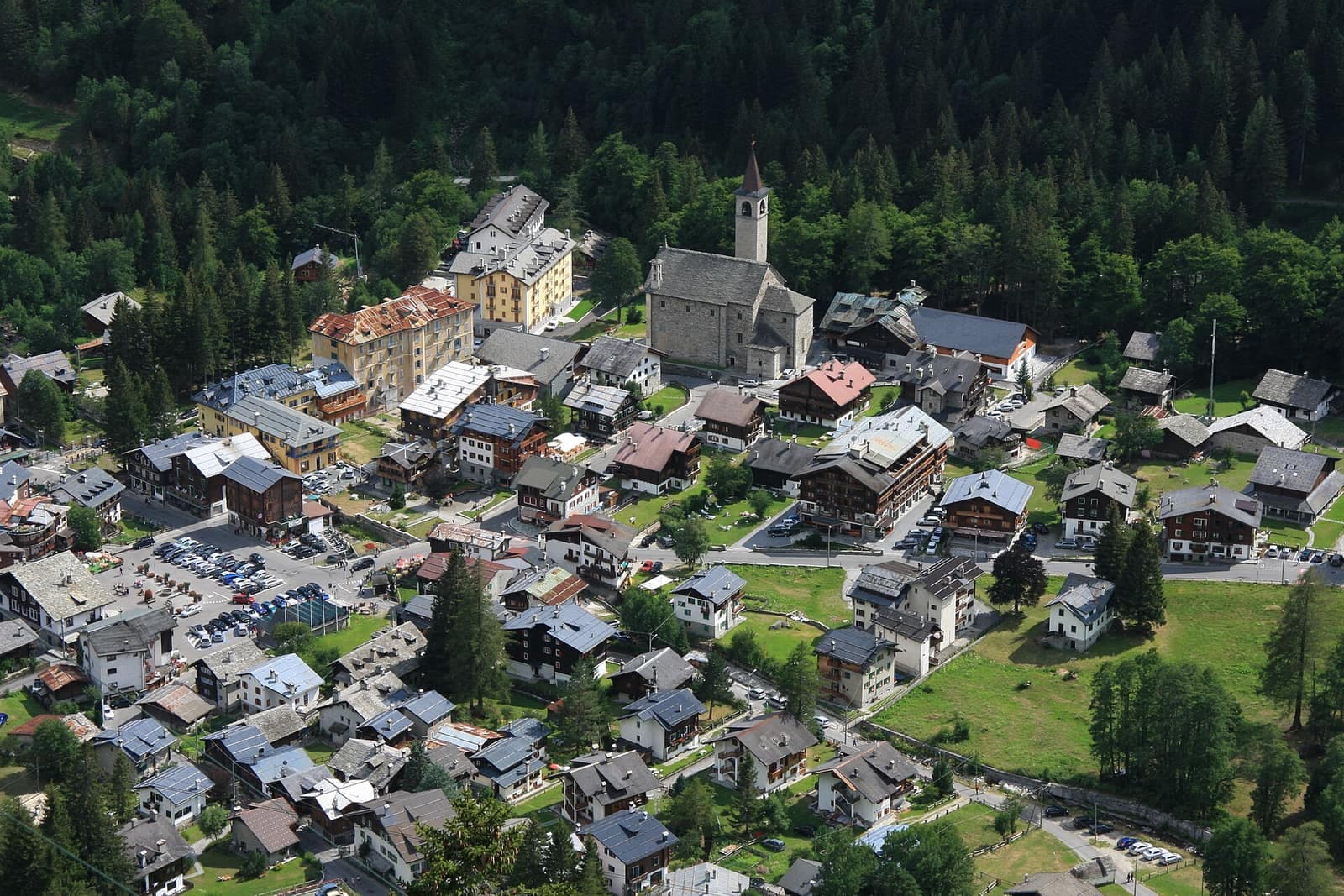 Macugnaga vista dall'alto, con le case e la chiesa tra i prati