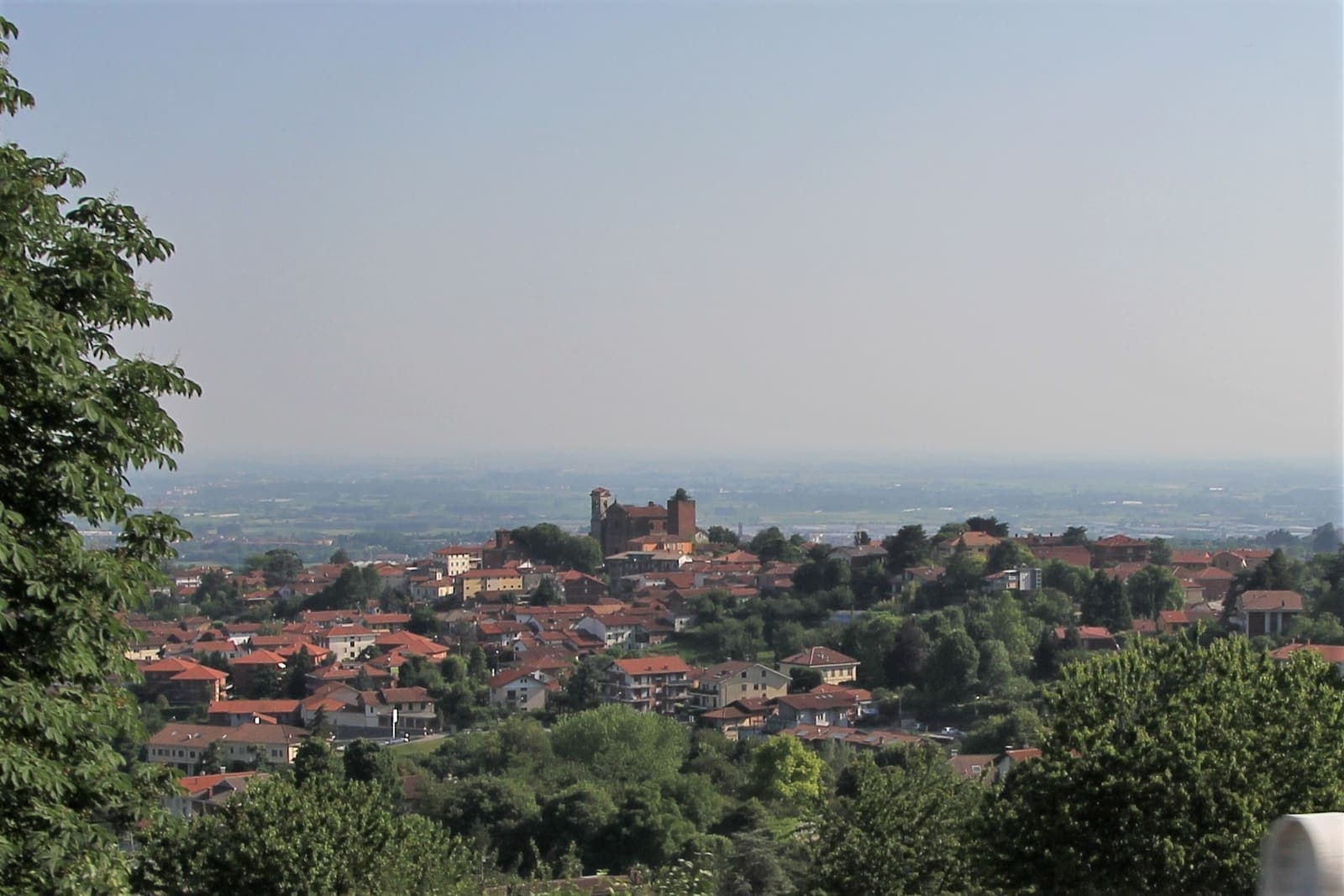 Panorama di Pecetto Torinese con i tetti tra il verde e la pianura sullo sfondo