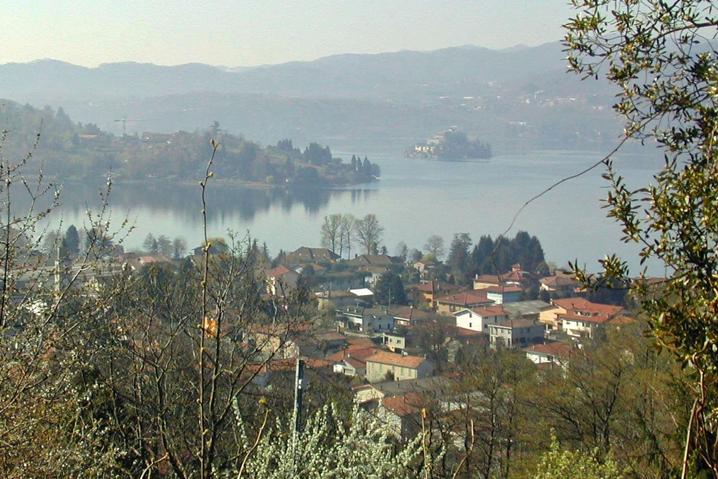 Pettenasco con le case tra il verde e il lago d'Orta sullo sfondo