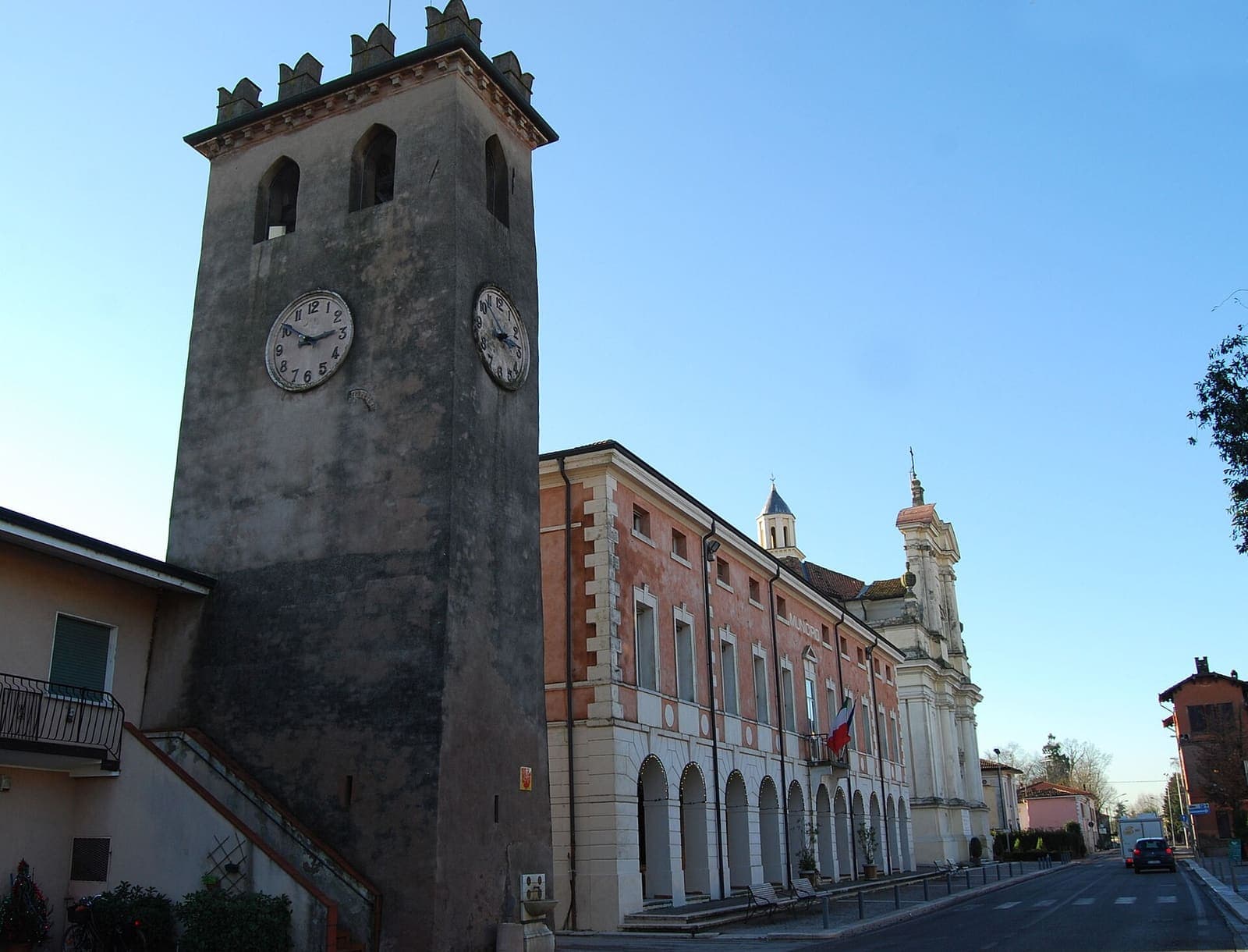 La torre civica di Rodigo con l'orologio accanto al municipio con il portico