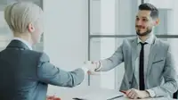 Due professionisti si stringono la mano oltre un tavolo